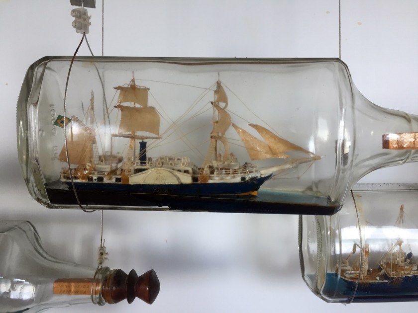 Miniaturas de barcos em garrafas de vidro