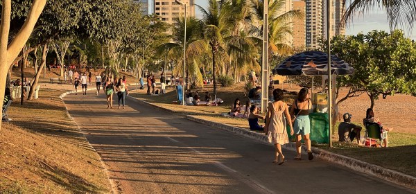 Pista de caminhada com areia de praia do lado direito e prédios ao fundo.