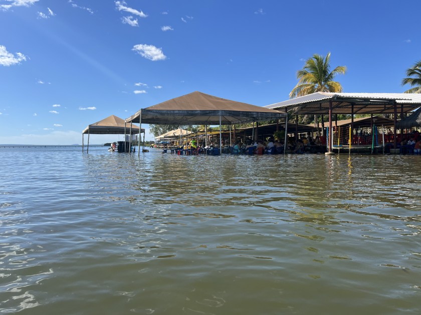 Barracas de praia à beira do lago em dia de céu azul.